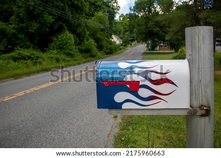 Urban street-side mailbox with blue and red flames painted on it