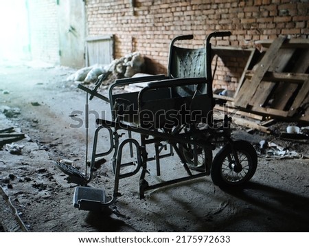 Old derelict wheelchair inside of the abandoned ruined hospital Royalty-Free Stock Photo #2175972633