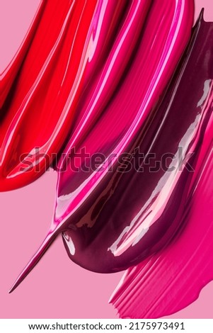 Palette of lip gloss red pink burgundy texture pink background