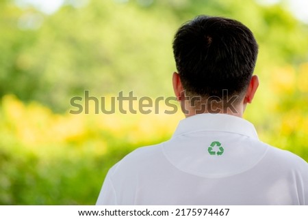 Men wear shirts made from PET bottles or recycled materials and have the Recycle symbol on the shirt with green blurred background.