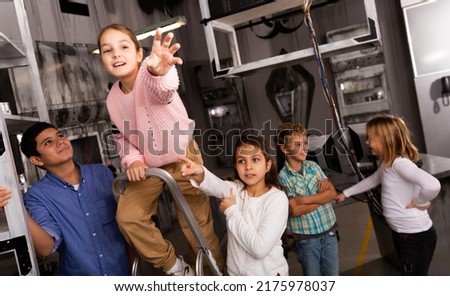 Children reach for key in the quest room. High quality photo