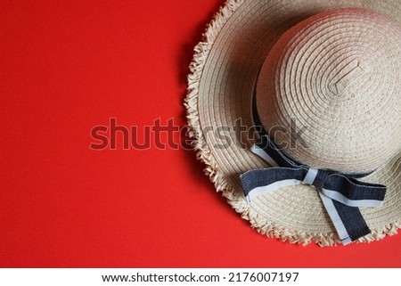 A bird's-eye view photo of a straw hat and a red background to the right