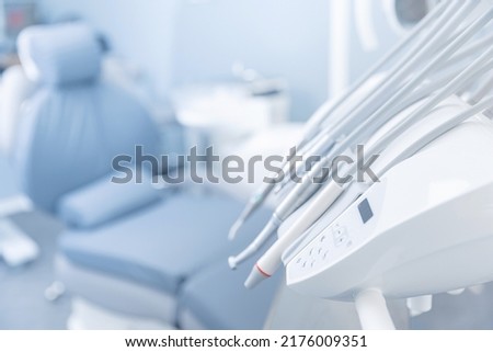 Different dental instruments and tools in dentists room office, blue toning. Royalty-Free Stock Photo #2176009351