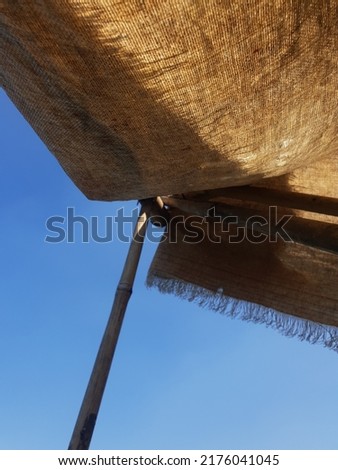 A wood and tent ceiling with a blue sky