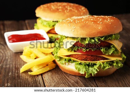 Big burgers on brown wooden background