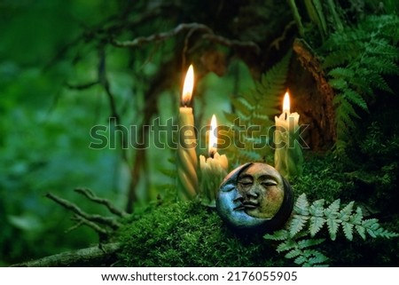 candles and symbolic moon amulet on dark forest background. pagan Wiccan, Slavic traditions for Litha. Witchcraft, esoteric spiritual ritual, magic practice. Mysticism, divination, occultism concept. Royalty-Free Stock Photo #2176055905