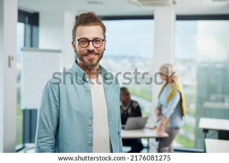 Portrait of a cheerful professor standing in a classroom with senior students. Royalty-Free Stock Photo #2176081275