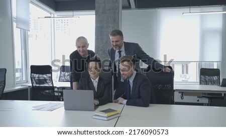 Happy office marketers team enjoying good presentation results looking at laptop