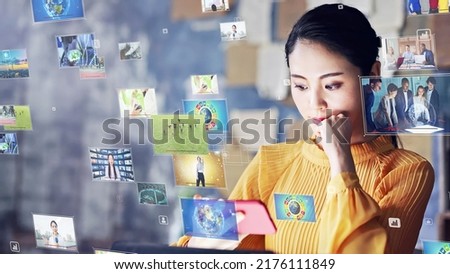 Young Asian woman watching Hologram screens. Head up display. Video distribution service. Virtual reality. Metaverse. Royalty-Free Stock Photo #2176111849