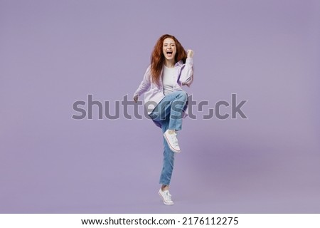 Full size body length energy active young redhead curly green-eyed woman 20s wears white T-shirt violet jacket doing aerobics training isolated on pastel purple color wall background studio portrait Royalty-Free Stock Photo #2176112275