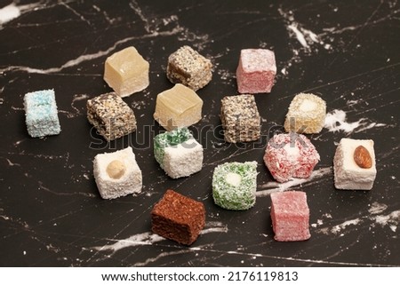 Cubes of traditional oriental sweets on a marble background, top view.