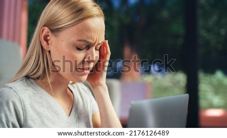 Human Going Through Headache: Close Up of a Female Working on Laptop Computer and Experiencing Discomfort and Migraine. Sudden Serious Pain Is Preventing Woman From Working on Laptop Computer. Royalty-Free Stock Photo #2176126489