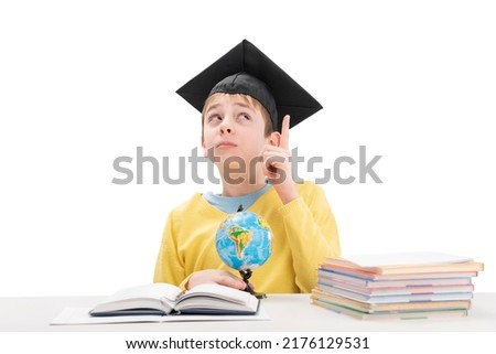 Student looks up thoughtfully and raised his index finger. Boy had an idea while doing homework. Straight-A student Royalty-Free Stock Photo #2176129531