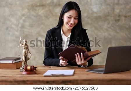Business woman Lawyer office. Statue of Justice with scales and a Female lawyer working on a laptop gavel and femida at the workplace. Legal law, advice and justice concept.