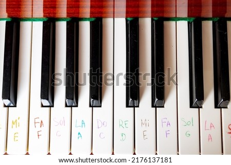 Learning to play the piano. Notes written with a felt-tip pen on the piano keys