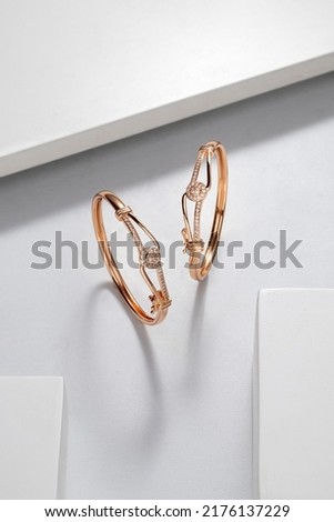Top view of two golden bracelets on white dramatic background with copy space Royalty-Free Stock Photo #2176137229