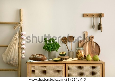Interior design of kitchen space with rattan commode, ladder, herbs, vegetables, food and kitchen accessories in modern home decor. Template. 