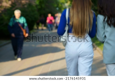 Blurred background. Young people are walking in the park.