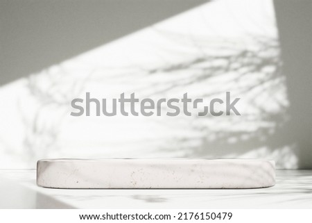 
Luxury marble table with plant shadow on white wall and stone podium for product placement display. Trendy neutral aesthetic mockup template for beauty and cosmetics scene. Royalty-Free Stock Photo #2176150479