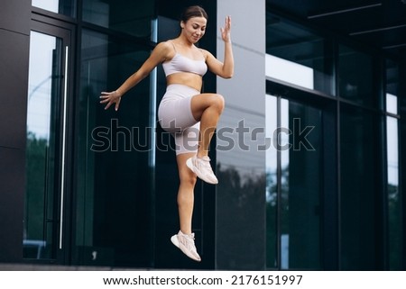 Sports woman jogging and jumping in the city