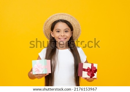 cheerful teen girl hold present box on yellow background