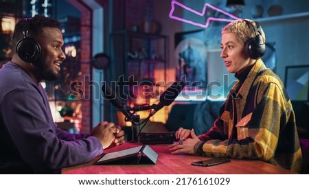 Two Young Stylish Radio Show Hosts Record Fresh Podcast Episode in Home Loft Studio Apartment. Attractive Energetic Co-hosts Discuss Important Topics Live on Air in an Evening Show. Royalty-Free Stock Photo #2176161029