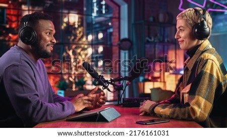 Stylish Podcast Host Makes Radio Show Interview with Up-and-Coming Young Artist in Loft Studio Apartment. Handsome African American DJ Discussing Lifestyle Trends with Beautiful Colleague.