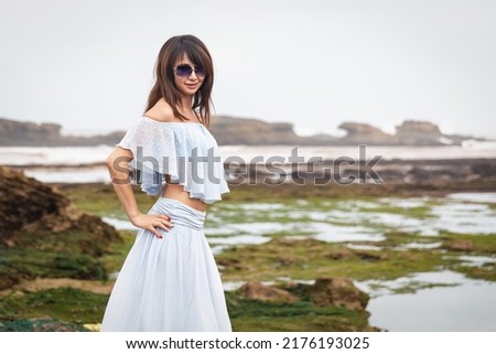 Brunette girl with glasses on the coast of the Atlantic Ocean . Essaouira. Morocco