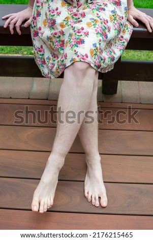 Natural unshaved hairy legs of a body positive young woman. Close up.