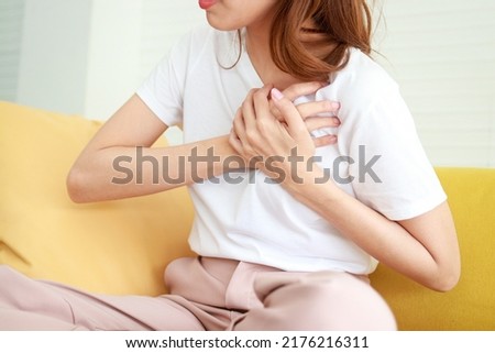 Asian women have chest pain. Heart palpitations are at risk of heart disease. Coronary artery disease. Hospital concept and health care Royalty-Free Stock Photo #2176216311