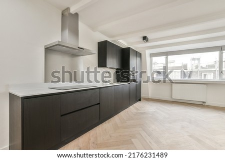 Interior of empty white kitchen with windows and wooden parquet floor