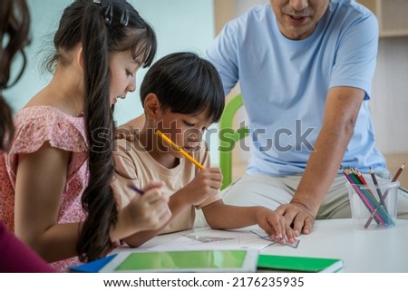 Father teaching children homework in living room.