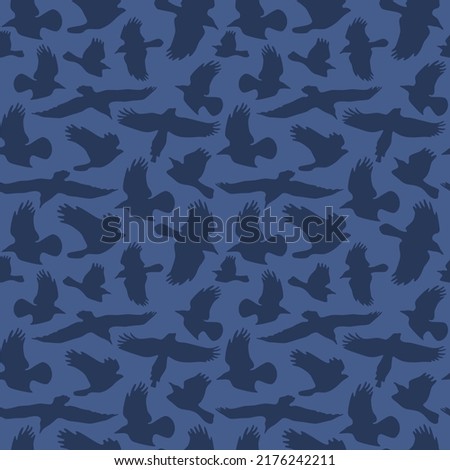 Seamless pattern with soaring birds silhouettes. Dark blue print on blue background