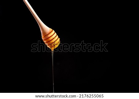 honey spoon on a black background. Blank space for text