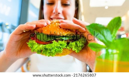 Veggie sandwich healthy vegan burger. Cute cheerful girl eating vegetarian hamburger with salad, avocado, vegetable. Hamburger vegan healthy diet food