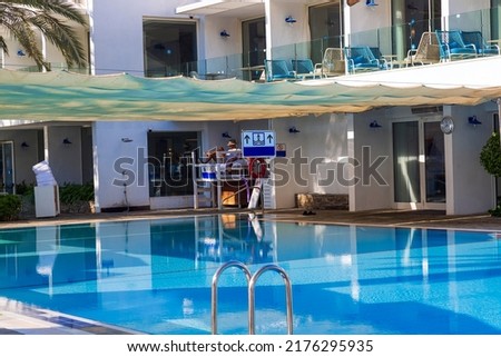 A small blue swimming pool under a canopy for relaxation, with beautiful lighting in backyard luxury house on a summer day, outdoor photo. indoor pool with blue water and stairs to the pool.
