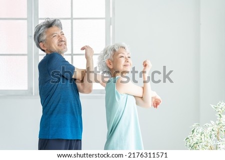 Asian sporty senior couple in the room Royalty-Free Stock Photo #2176311571