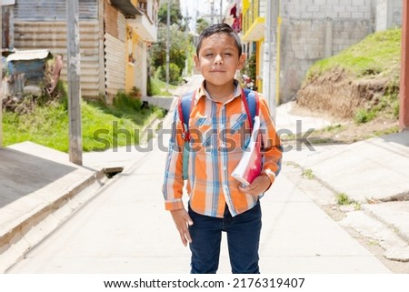 Happy Hispanic boy ready to go to school with his backpack and notebooks - Latin boy on his way to school Royalty-Free Stock Photo #2176319407