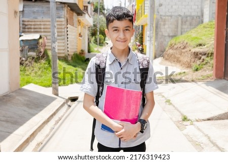 Happy Hispanic boy ready to go to school with his backpack and notebooks - Latin boy on his way to school - Happy boy in town Royalty-Free Stock Photo #2176319423