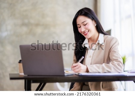 Asian Businesswoman working on laptop at the office with documents on his desk, doing planning analyzing the financial report, business plan investment, finance analysis concept