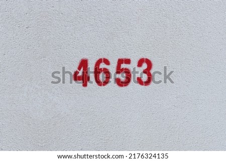 Red Number 4653 on the white wall. Spray paint.
