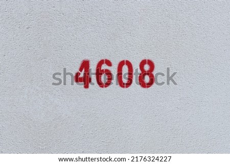 Red Number 4608 on the white wall. Spray paint.
