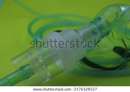 The green nasal mask is held by someone's hand which the patient uses to breathe oxygen when he has a respiratory disease or lacks oxygen Royalty-Free Stock Photo #2176328527