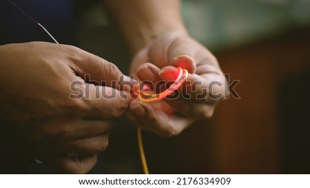 Optical fiber with demonstration of excessive bending of the cable leading to loss within the cable by a concept technician. technology and maintenance. Royalty-Free Stock Photo #2176334909