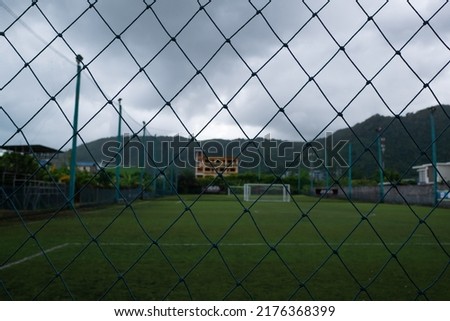 View of the soccer field through the fence grid