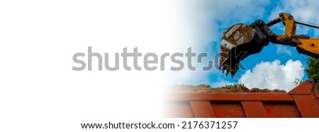 Orange excavator loading soil into a dumper truck on construction site . Dig in the agricultural area. Banner with copy space. High quality photo
