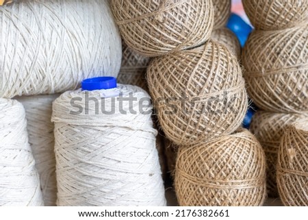 spools of thread on shelf for sale in industrial store,shop,market.jute twine natural twisted rope placed one over another.brown,white and blue colors thread spools.alpaca yarn,cotton,wool factory Royalty-Free Stock Photo #2176382661