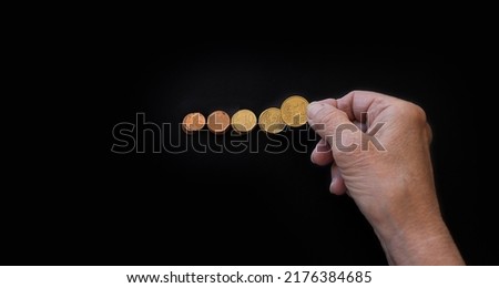 close-up, the hands of the old woman put the coins in piles. Poster on black background with copy paste for text. The concept of poverty, small benefits for the elderly, financial crisis, low pensions