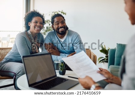 Happy African American couple communicating with financial advisor during a meeting in the office. Royalty-Free Stock Photo #2176410659