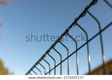Fence made of steel bars. Fence made of netting in parking lot. Steel mesh. Obstacle from penetration.